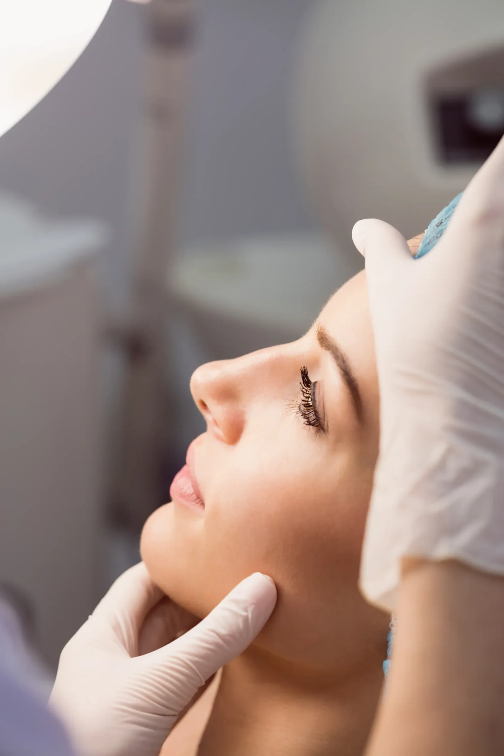 Rhinoplasty doctor examining womans face cosmetic treatment scaled