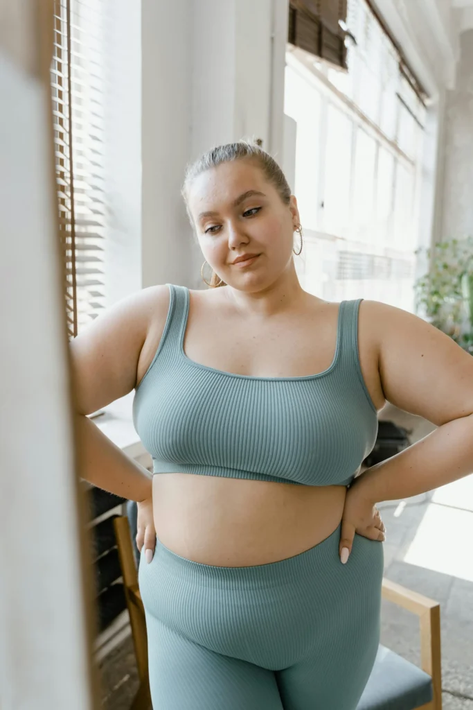 Woman in green activewear posing confidently.