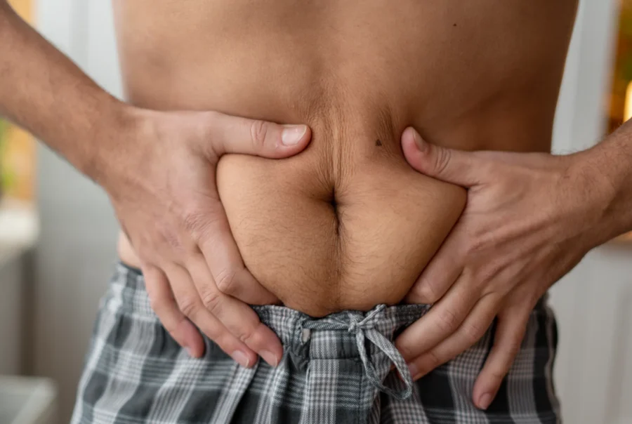 Person holding stomach, showing discomfort.