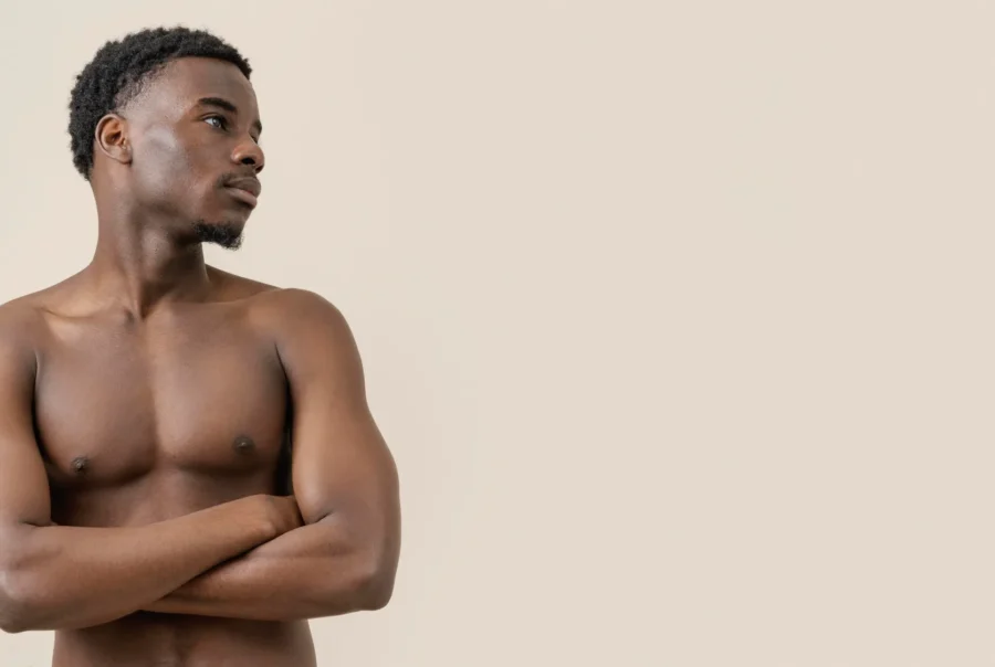 Male Abdominoplasty Muscular man with crossed arms.