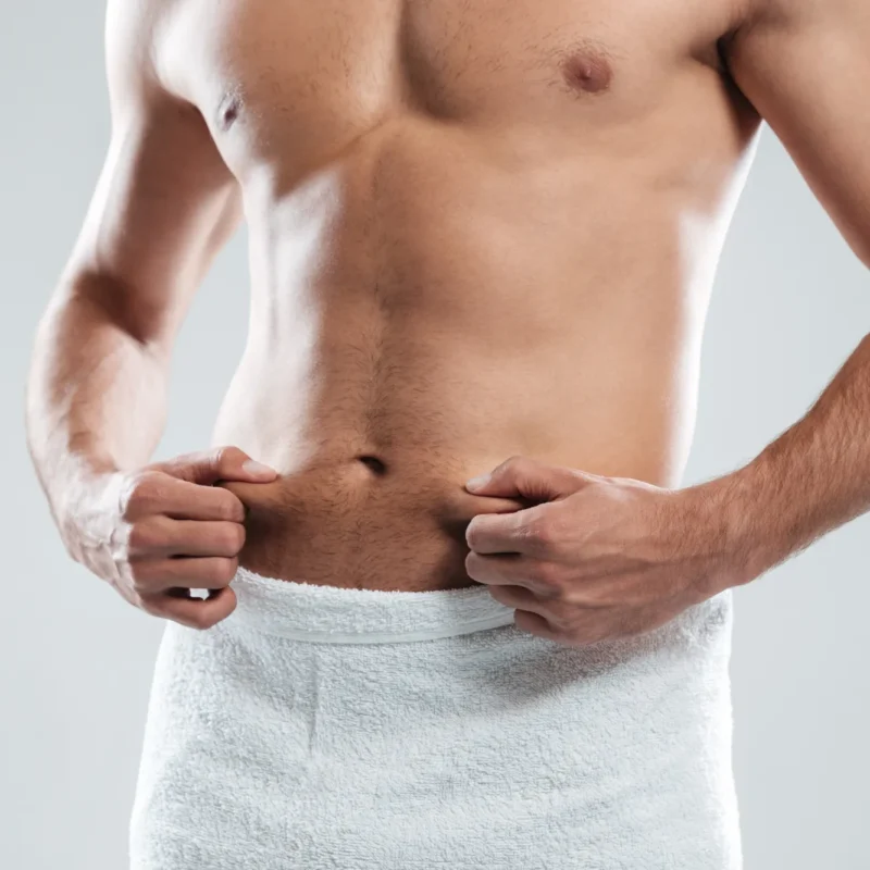 Male Abdominoplasty Man holding towel around waist